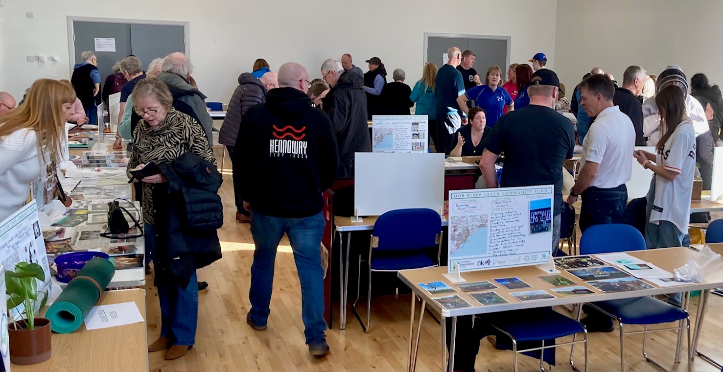 PB event in Wellesley Parish Hall. Tables displaying all 25 projects with people networking and each voting for 3 projects